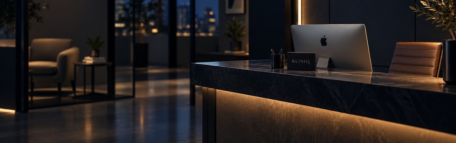 A reception counter at night, a KlinIQ card and a monitor on the stone, warm light under the desk